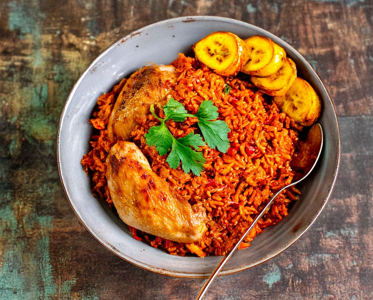 Jollof Rice War A bowl of flavorful Jollof Rice with vibrant spices and herbs, representing the best Ghanaian and Nigerian Jollof Rice battle.
